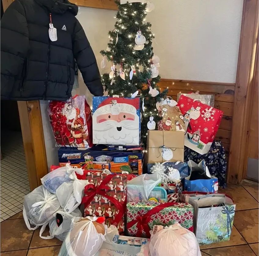Gifts, clothes, and a winter coat gathered for an adopted family
