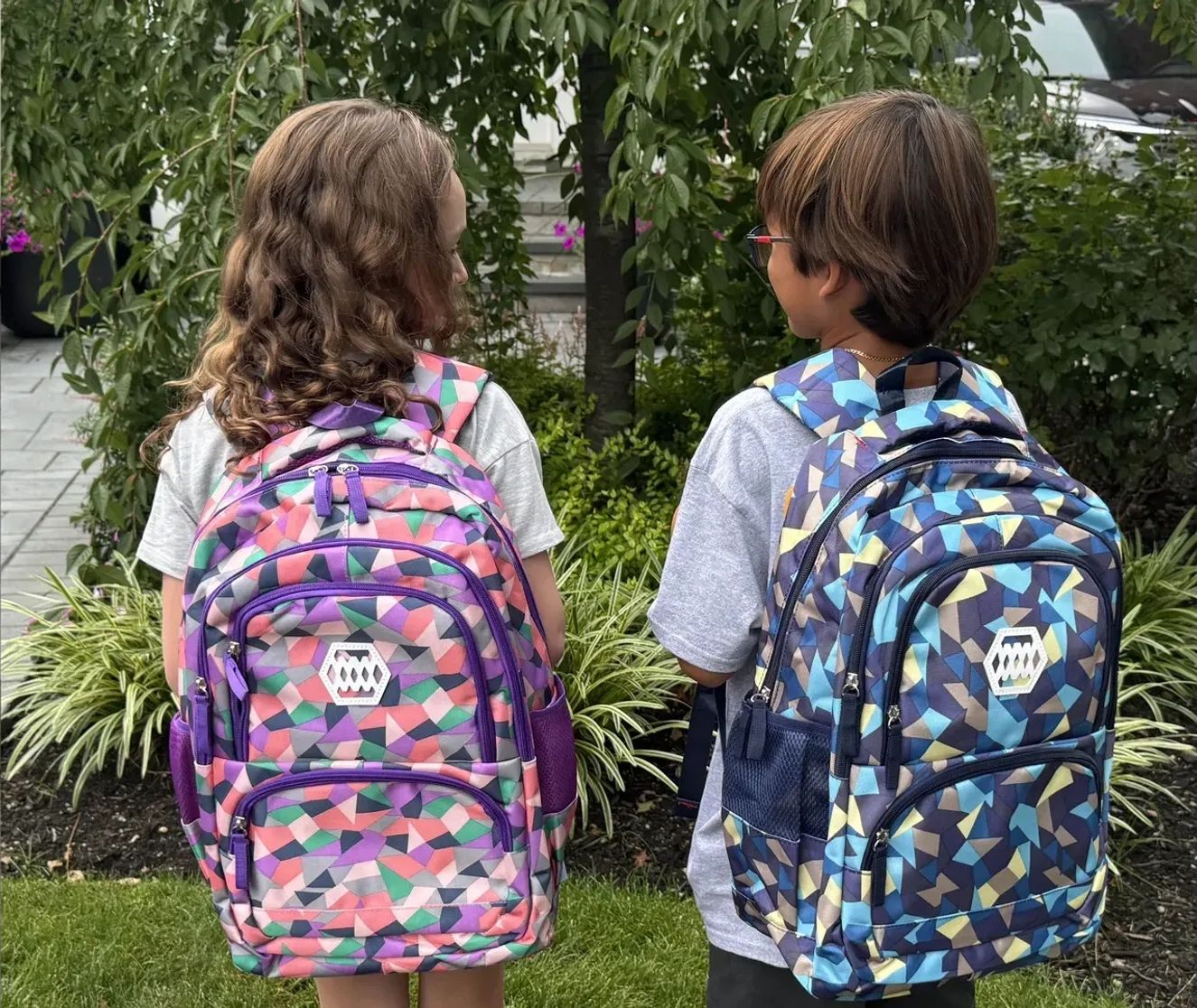 Two kids wearing new backpacks