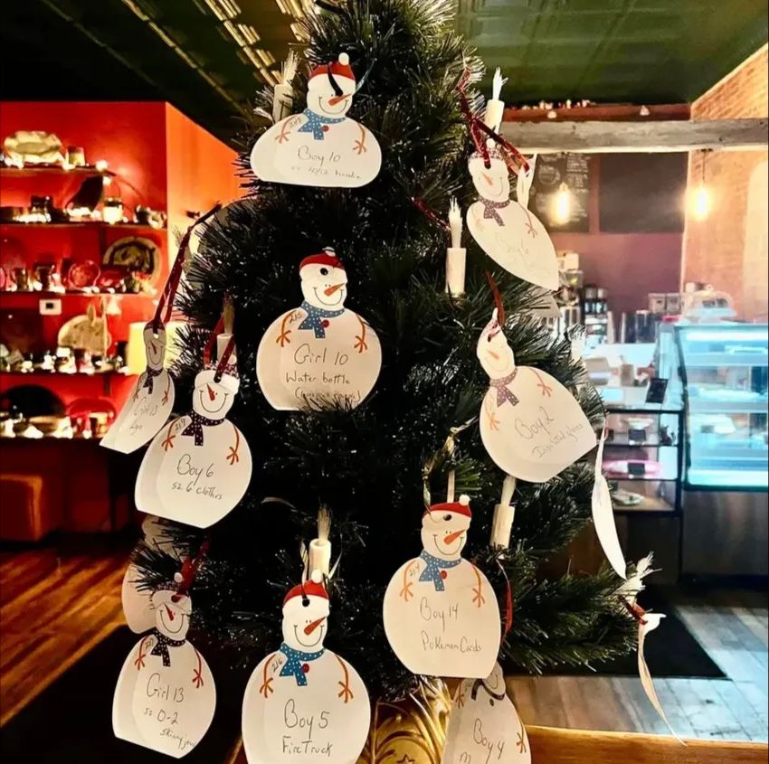A Miracle Tree covered in snowman-shaped gift tags, each with a child's wish list